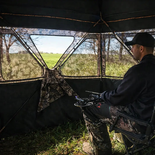 Hunter seated inside Muddy Epic Camo Infinity ground hunting blind during early morning hunt