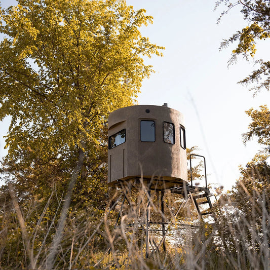 Banks Outdoors The Stump Sequoia Phantom tower blind installed in field, low-angle lifestyle shot with trees and tall grass