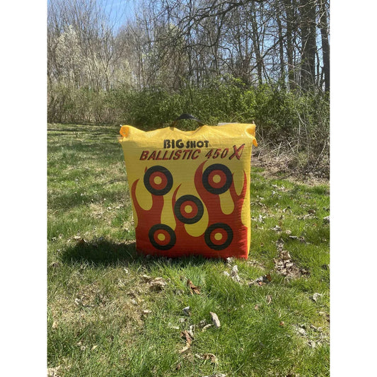 Big Shot Ballistic 450X archery bag target front face with flame graphics, standing on grass in outdoor field