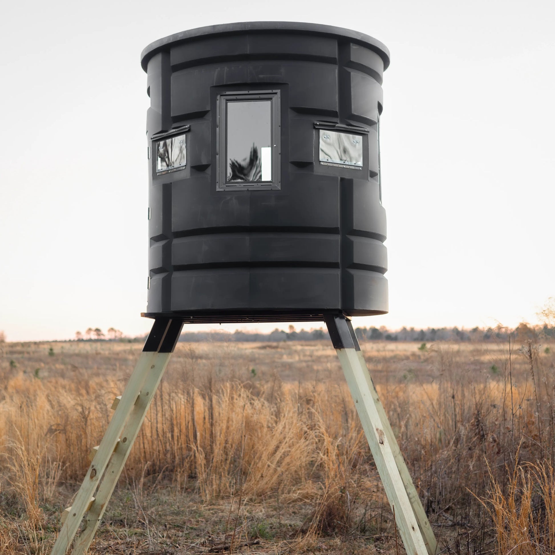 Rear view of Sportsmans Condo Bow Condo elevated deer blind with three windows in an open field