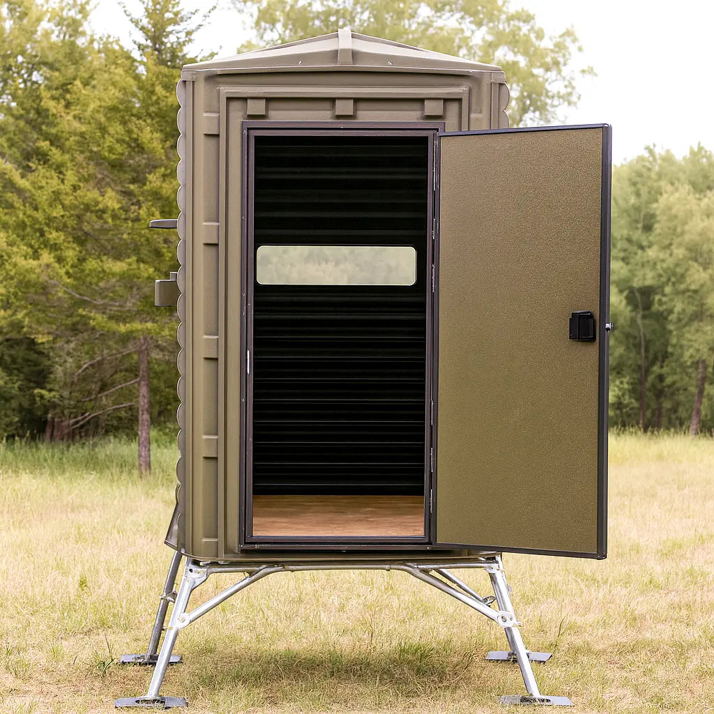 Angled view of The Blynd 4x4 Hunting Deer Blind elevated on a tower stand, showing door and side windows for 360-degree hunting access.

