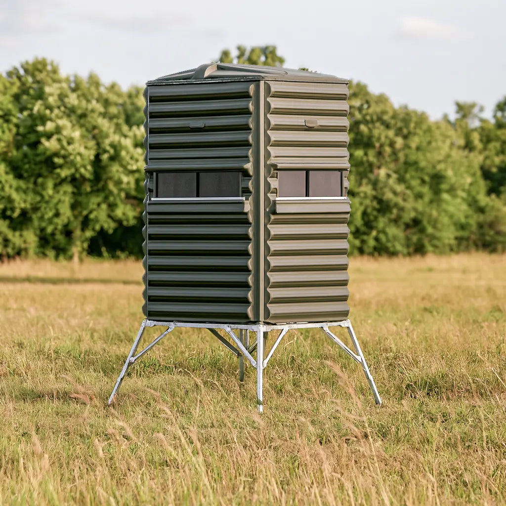 Side view of The Blynd 4x4 Deer Hunting Blind on elevated metal tower, with large shooting windows for wide field coverage.

