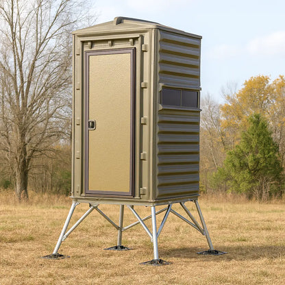 Side profile of The Blynd 4x4 Bow Hunting Deer Blind on tall steel stand in a grassy field.

