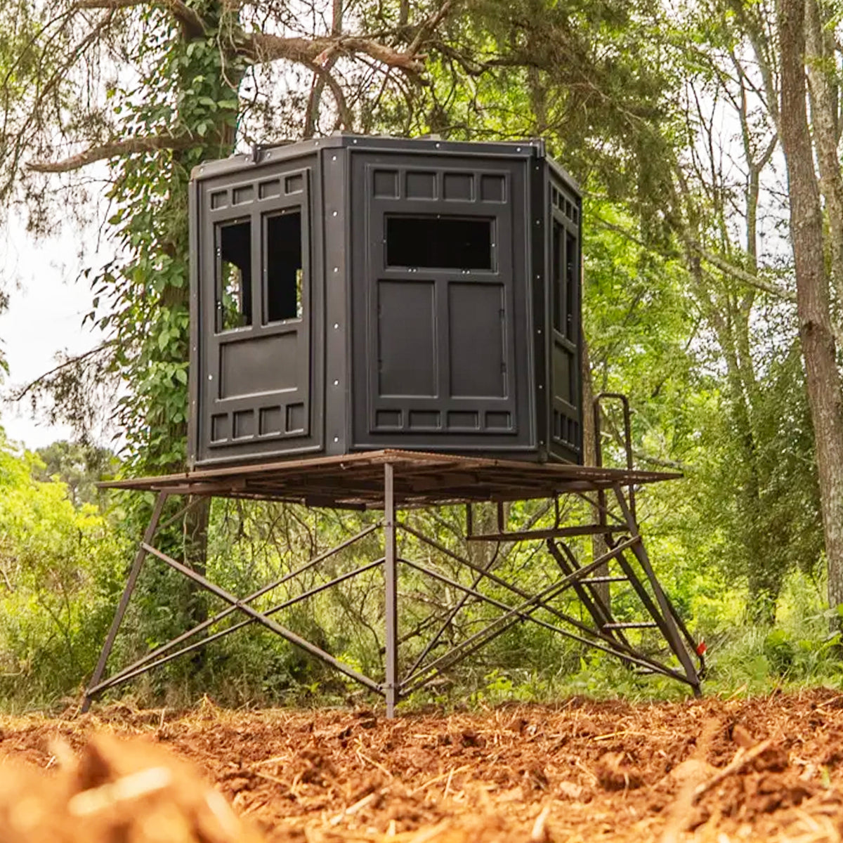 Booner 6-Panel deer hunting blind elevated on a steel tower platform in a wooded setting, durable elevated hunting blind sold by Outdoors For Less