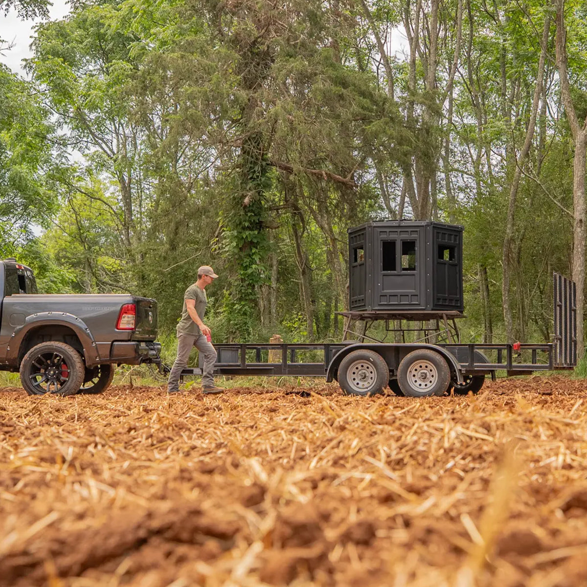 Booner 6-Panel deer hunting blind loaded on a trailer for transport and setup in a wooded property, heavy-duty hunting blind sold by Outdoors For Less