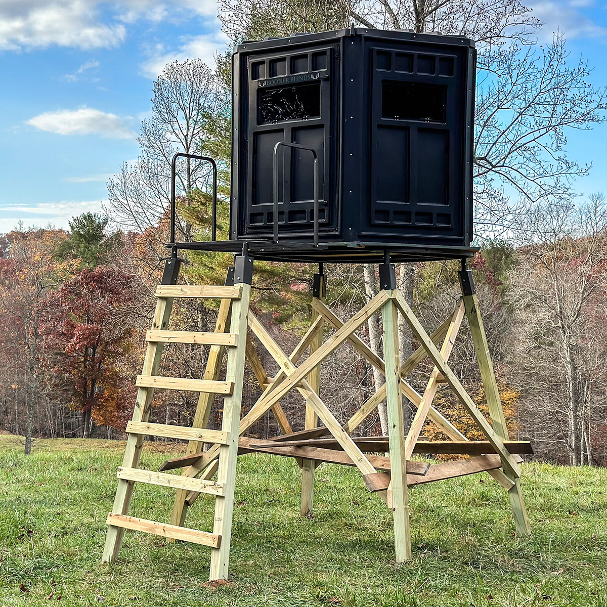 Booner 6-Panel deer hunting blind elevated on a wooden tower with ladder access, elevated hunting blind setup sold by Outdoors For Less