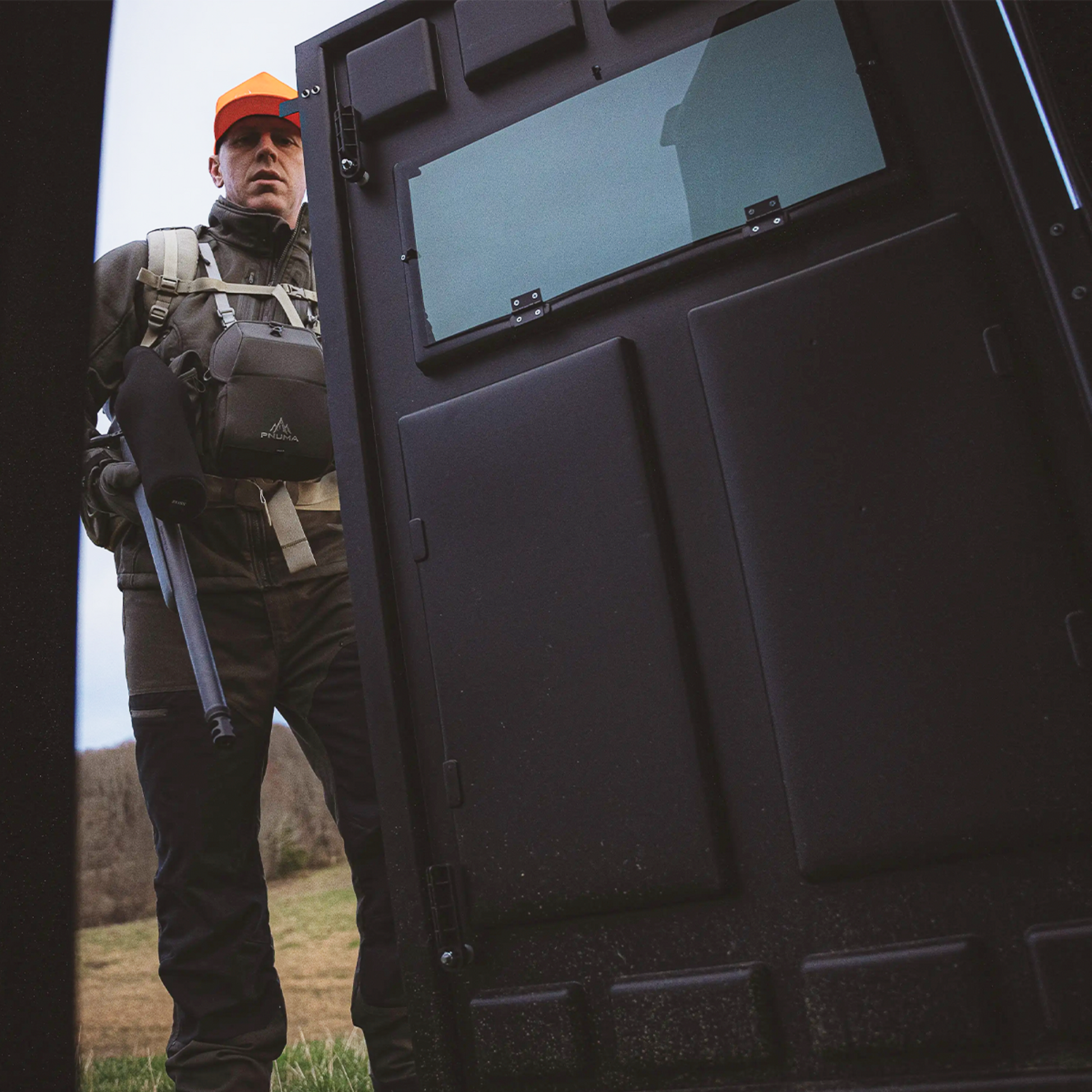 Hunter entering a Booner deer hunting blind with door open, rugged ground blind designed for rifle hunting sold by Outdoors For Less