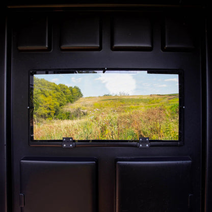 View through a Booner deer hunting blind shooting window overlooking a grassy field, interior perspective highlighting visibility and quiet window design sold by Outdoors For Less