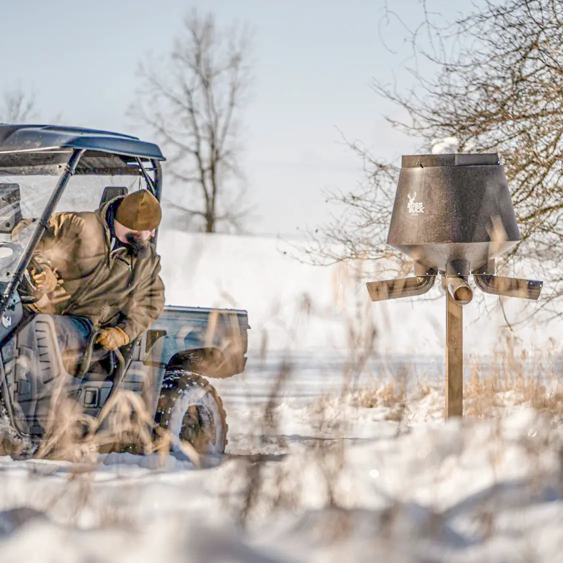 Boss Buck 200lb Post-Mounted Deer Feeder being unloaded from pickup truck — rotomolded gravity deer feeder ideal for hunting property feed stations.