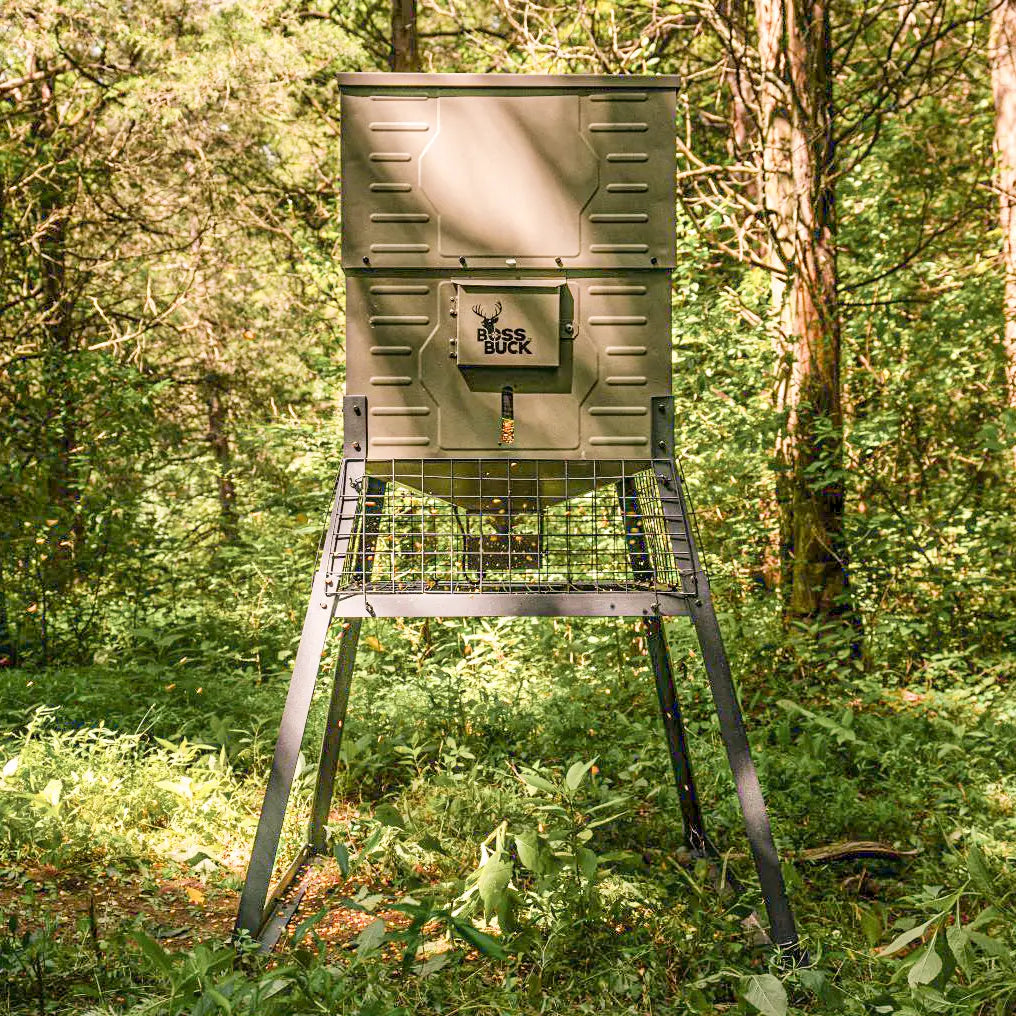 Boss Buck 300lb Stand & Fill Automatic Sled Deer Feeder standing in open field — compact tan feeder with top-fill lid, steel skid base, and 12-volt timer system.