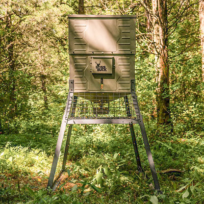 Boss Buck 300lb Stand & Fill Automatic Sled Deer Feeder standing in open field — compact tan feeder with top-fill lid, steel skid base, and 12-volt timer system.