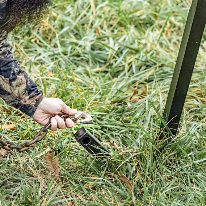 Boss Buck 600lb Stand & Fill Automatic Sled Deer Feeder in tall grass — tan feeder with spinner head, digital timer, and stable sled base ideal for deer hunters and land managers.