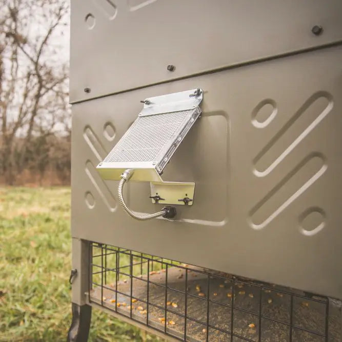 Boss Buck 600lb Stand & Fill Automatic Sled Deer Feeder showing spinner system and steel sled frame — tan rotomolded hopper with heavy-duty design for deer feeding and wildlife management.