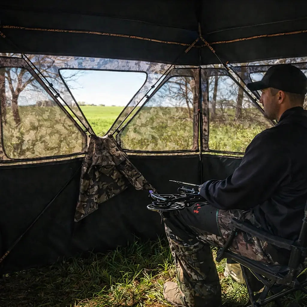 Hunter seated inside Muddy Epic Camo Infinity ground hunting blind during early morning hunt