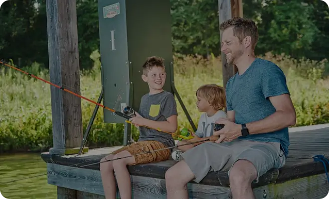 Man and two boys fishing together outdoors