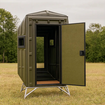 The Blynd 4x4 Bow Hunting Deer Blind with open door revealing interior, placed in a grassy field with dense tree line—engineered for bow hunters seeking quiet access and concealment.