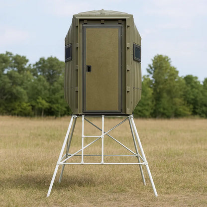 The Blynd 4x4 Bow Hunting Deer Blind elevated in a grassy field with trees in the distance, ideal for visibility and scent control.