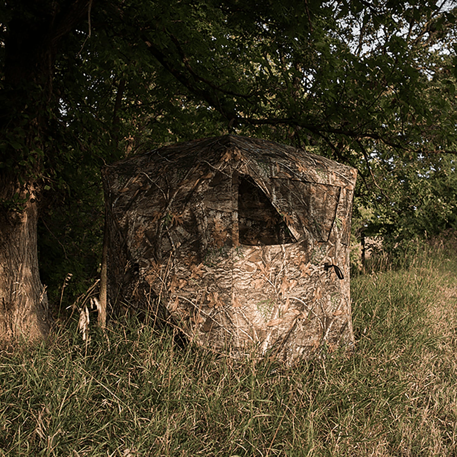 Ameristep Care Taker ground hunting blind set up in a wooded area, fire-retardant camo fabric designed for safe deer hunting