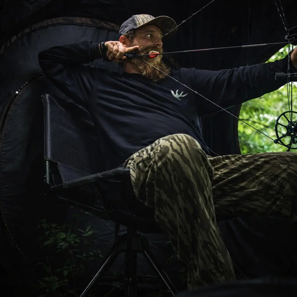 Hunter seated on Ameristep Silent Swivel 360 hunting blind chair inside ground blind