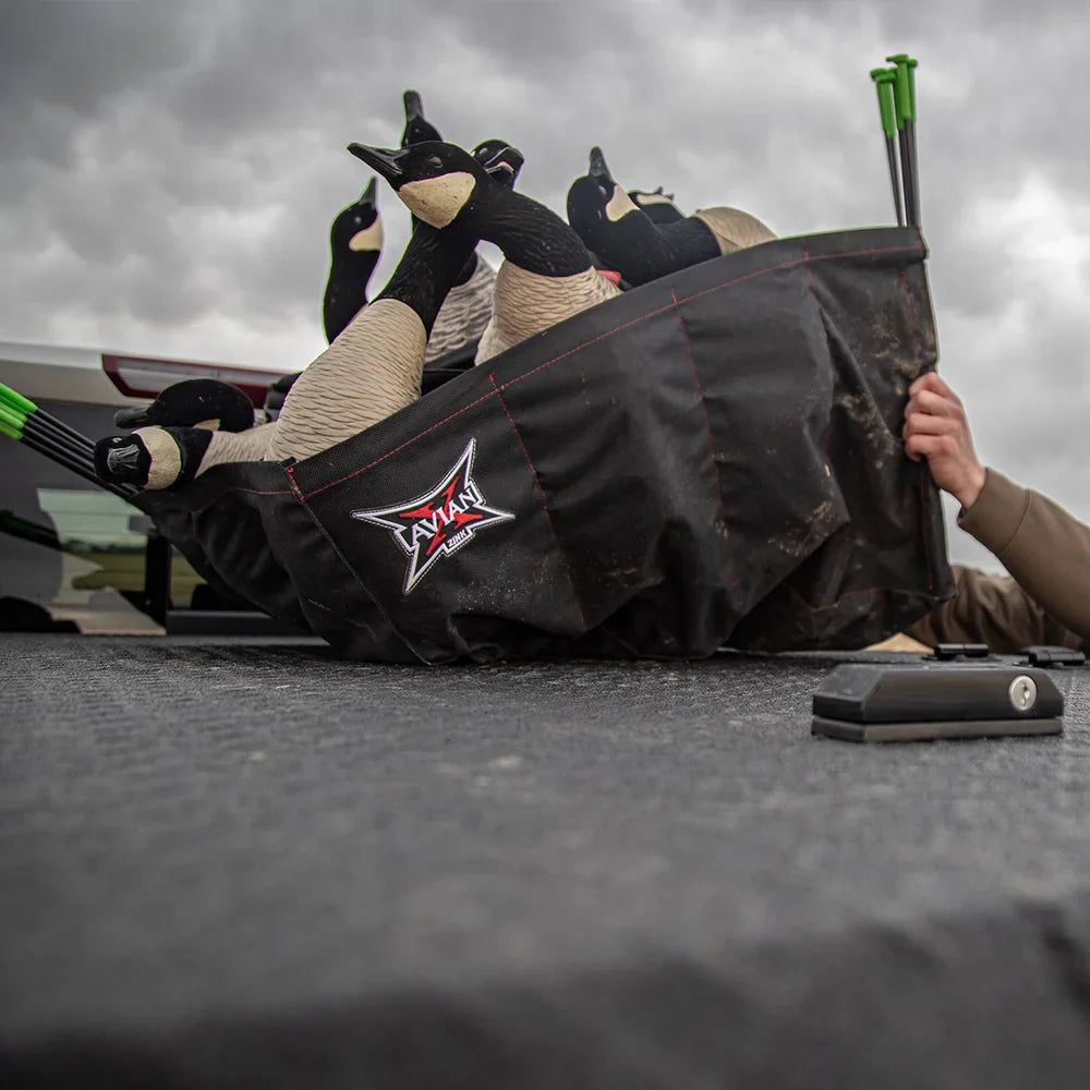 Avian-X branded decoy bag loaded with AXP Honkers decoys on tailgate with hunter