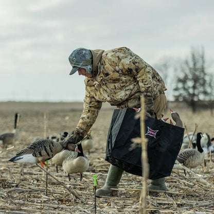 Hunter placing Avian-X AXP Specklebelly decoy with Avian-X carry bag in cornfield
