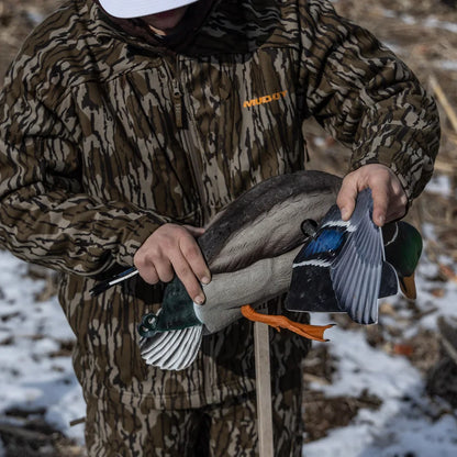 Hunter in Mossy Oak camo assembling wings on Avian-X Powerflight Mallard decoy in the field