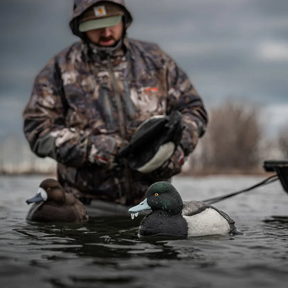 Avian-X TopFlight Bluebills floating decoys being deployed by camo-clad hunter on open water