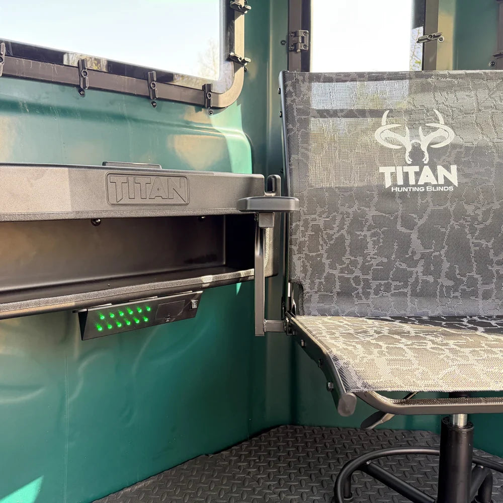 Titan 12V Light Kit installed under shelf inside Titan hunting blind next to Titan camo swivel chair, daytime
