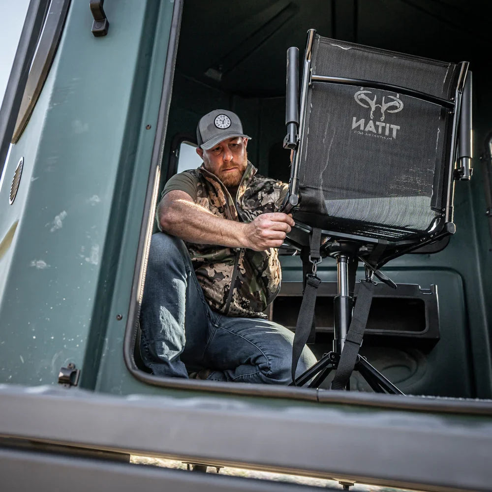 Hunter adjusting Titan Hunting Blinds Swivel Chair viewed through blind window