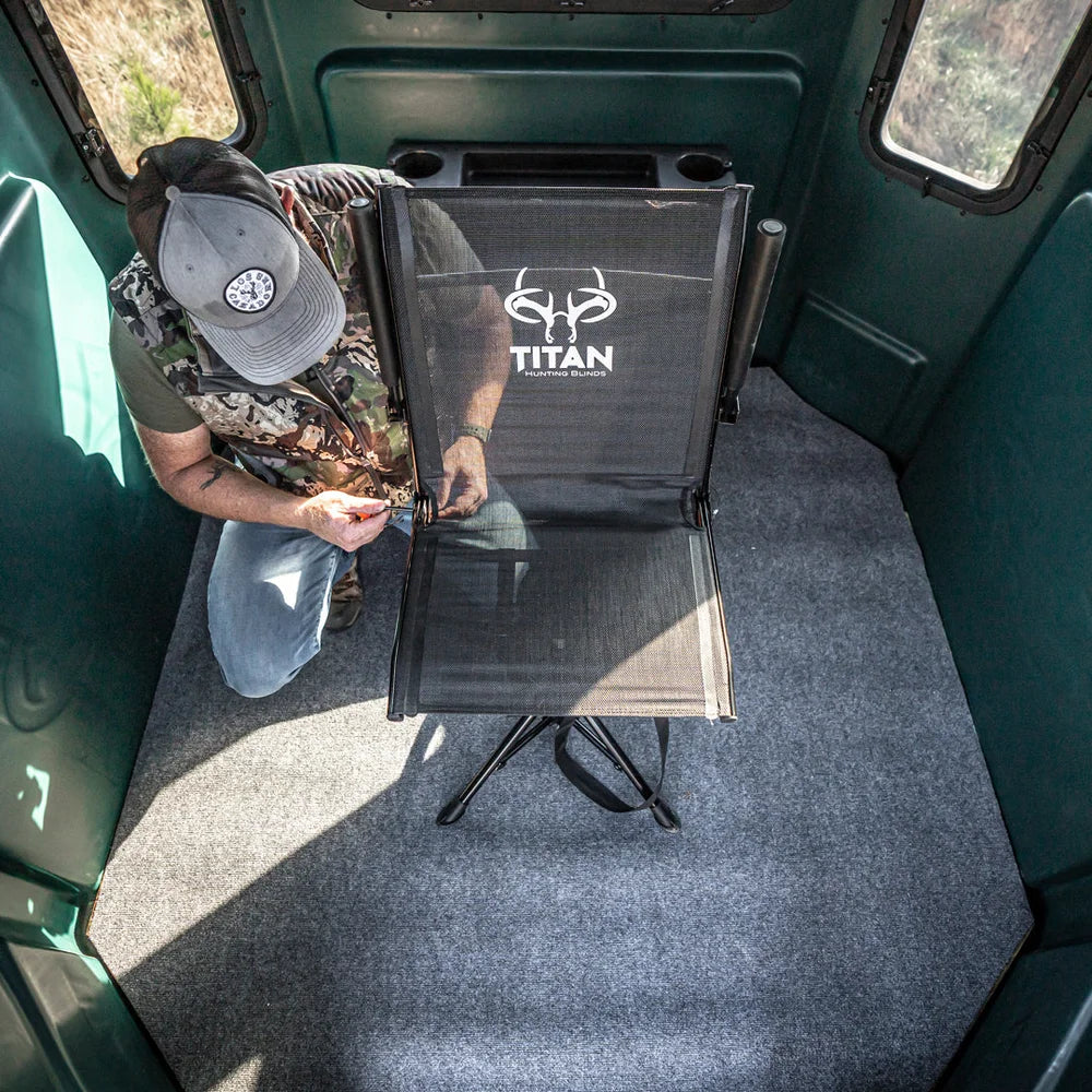 Hunter setting up Titan Hunting Blinds Swivel Chair inside a green hunting blind, overhead view