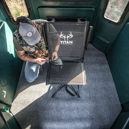 Hunter setting up Titan Hunting Blinds Swivel Chair inside a green hunting blind, overhead view