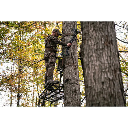 Hunter in camo climbing Trophy Treestands Freedom ladder stand with compound bow in fall woods
